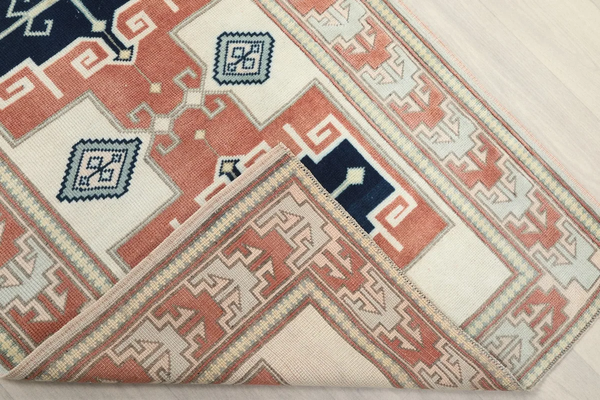 Corner of the runner folded to reveal the cotton foundation and the reverse side of the hand-knotted construction.