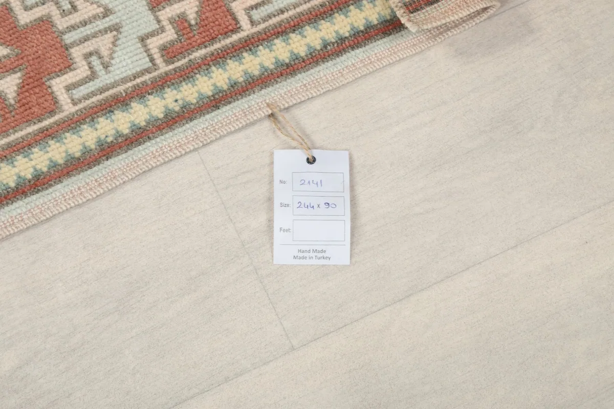 Small tag attached to the runner, indicating 'Hand Knotted' and 'Made in Turkey' details.