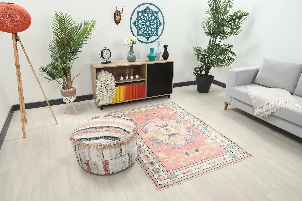 Angle view of the pink Anatolian rug in a room, showing its placement relative to furniture