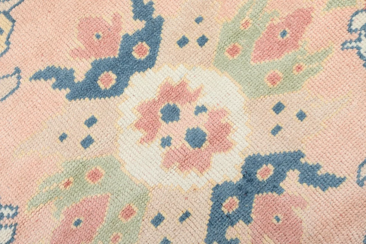 Extreme close-up showing the texture of the hand-knotted wool pile and the intricate central floral pattern