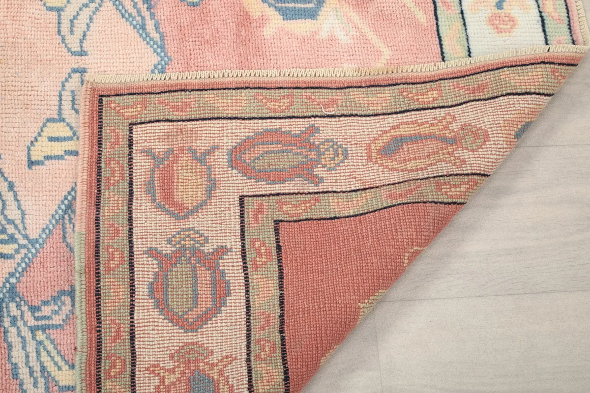 Another view of the rug's corner folded, showing the reverse side and knotting detail