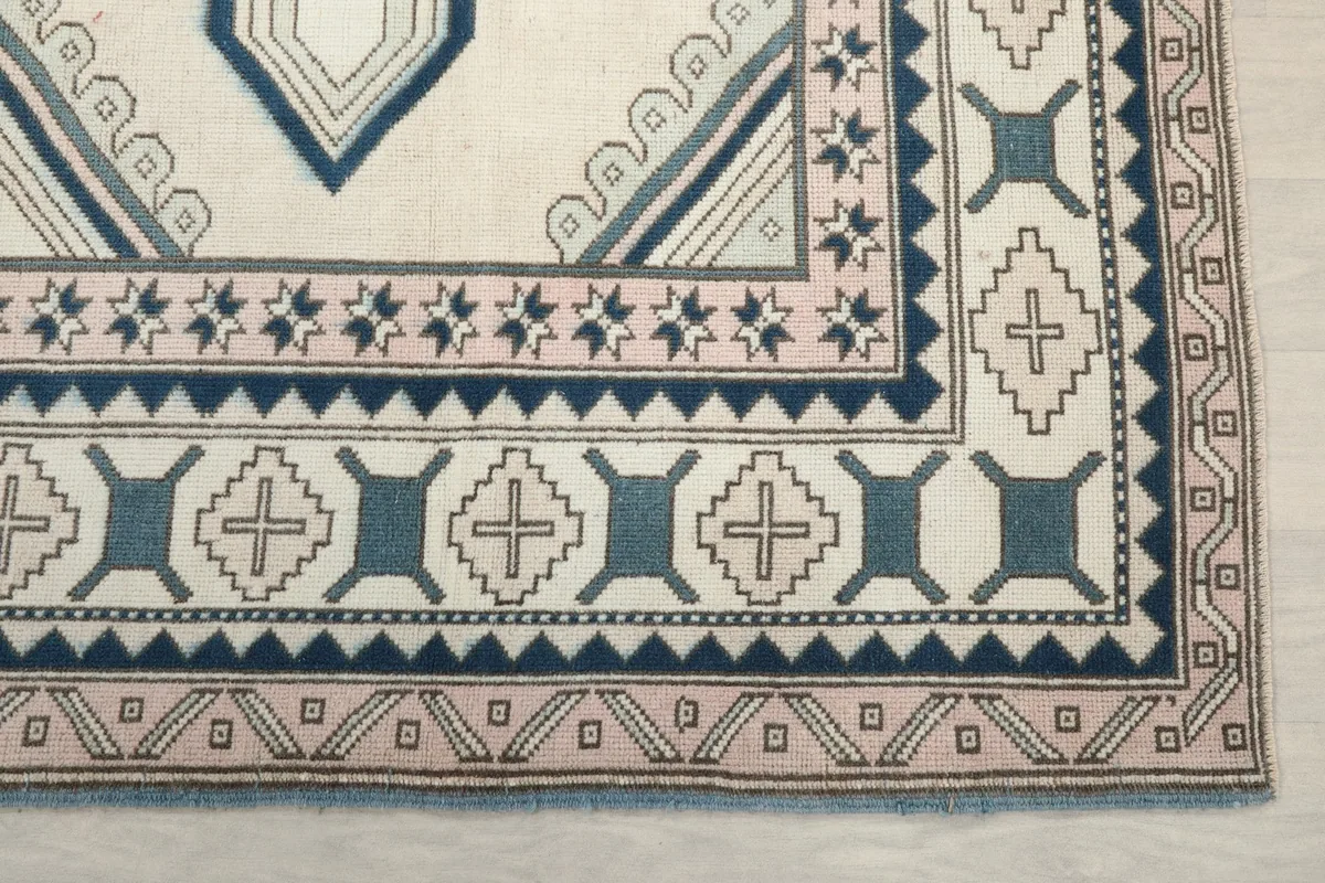 Detailed view of the corner border with rose and blue geometric patterns