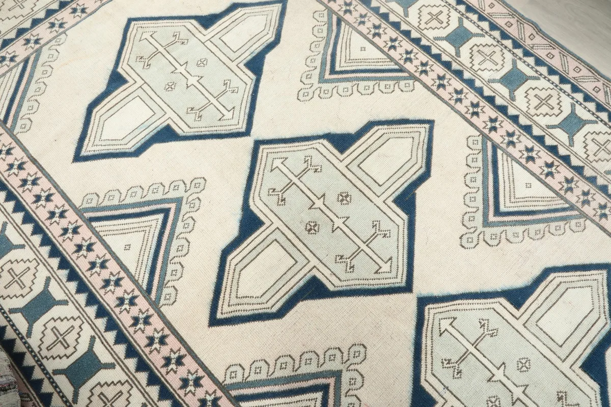 Close-up of the central blue geometric motifs and ivory field