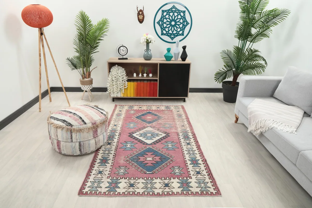 Rose geometric rug placed in a modern living room setting with a gray sofa and wooden console