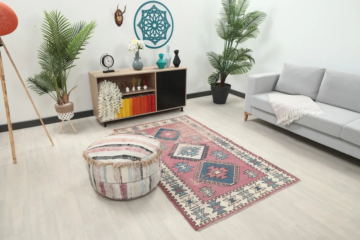 Angle view of the rose and blue rug in a living space, showing its size in relation to furniture