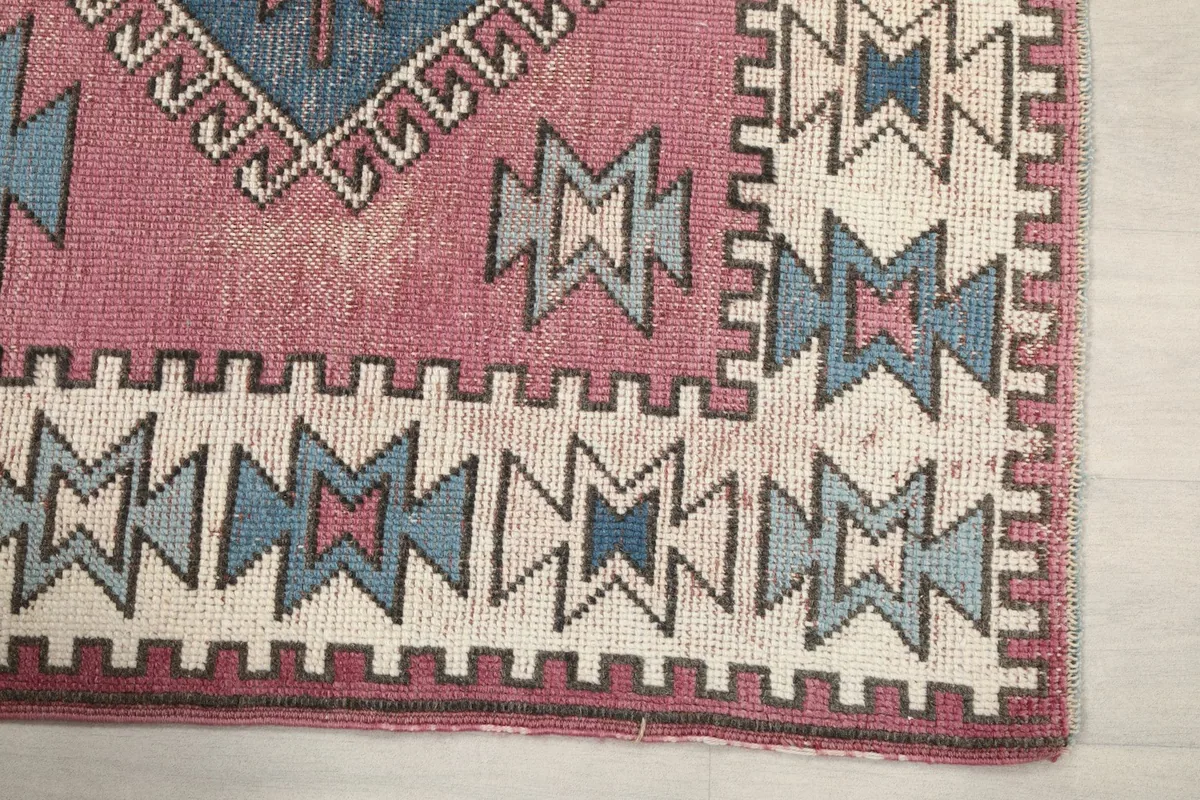 Detailed view of the ivory border with geometric motifs and the rose field