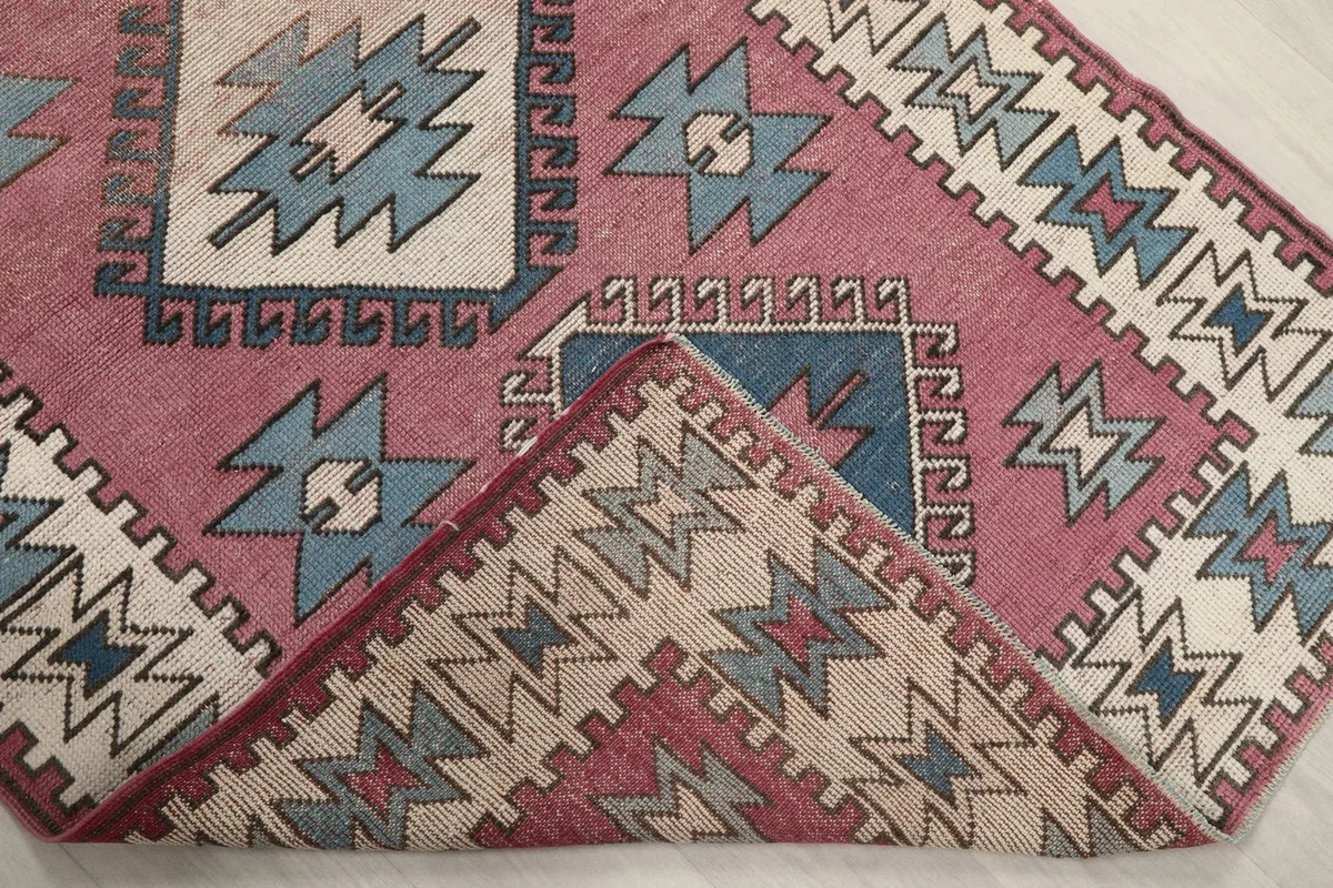 Corner of the rug folded back to show the reverse side of the hand-knotted wool pile