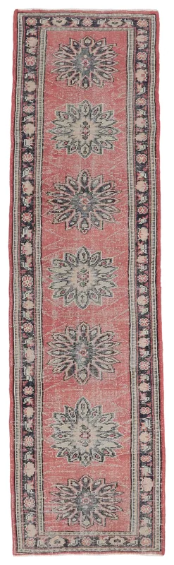 Full overhead view of the rose and navy geometric Anatolian runner rug on a white background.
