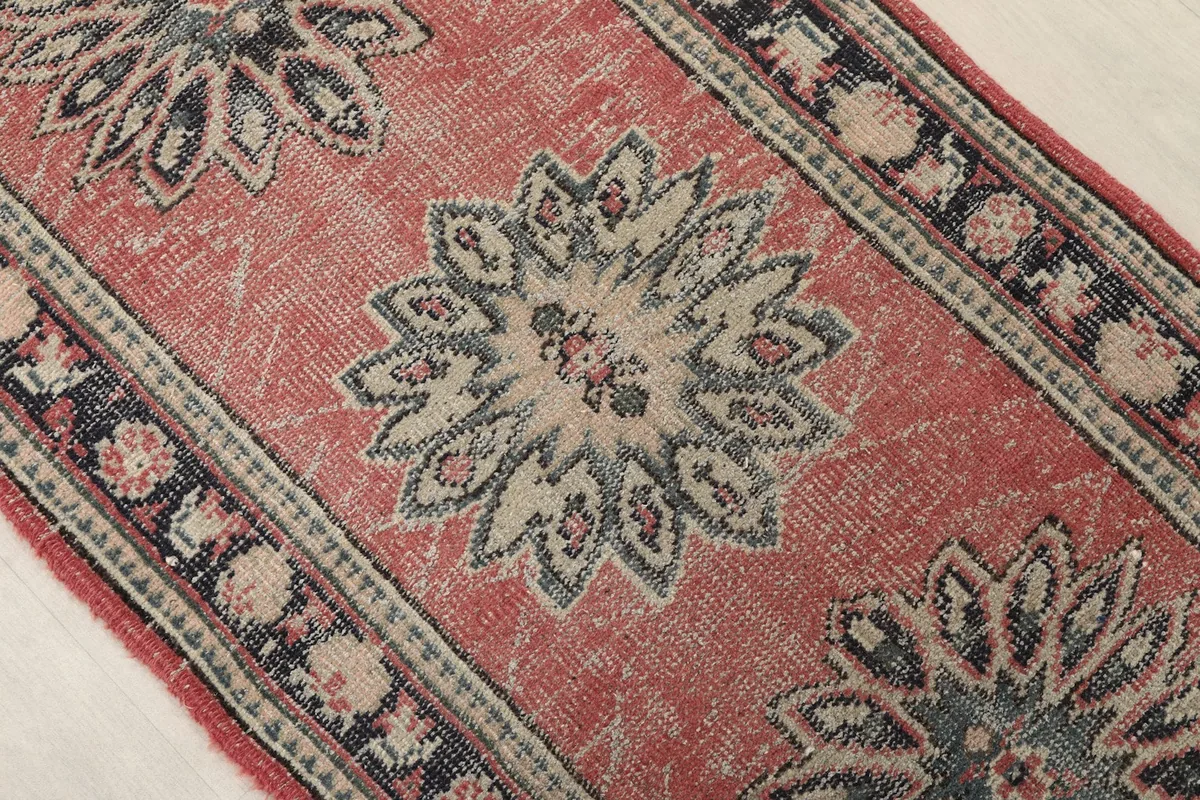 Close-up of a central geometric medallion and the surrounding rose field with subtle wear.