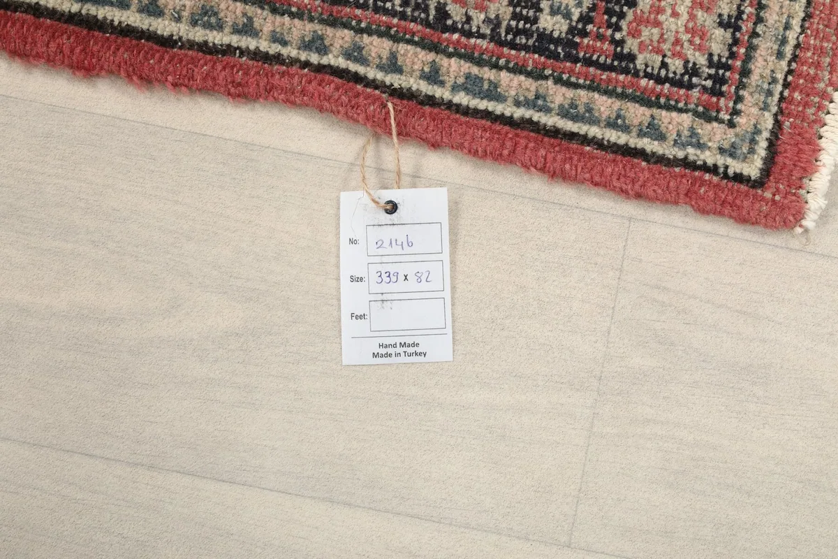 Close-up of the rug's back with a product tag, indicating its handmade origin from Turkey.