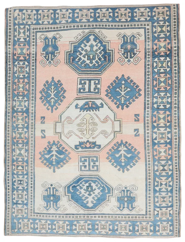 Full top view of the vintage rose and blue Anatolian area rug on a white background
