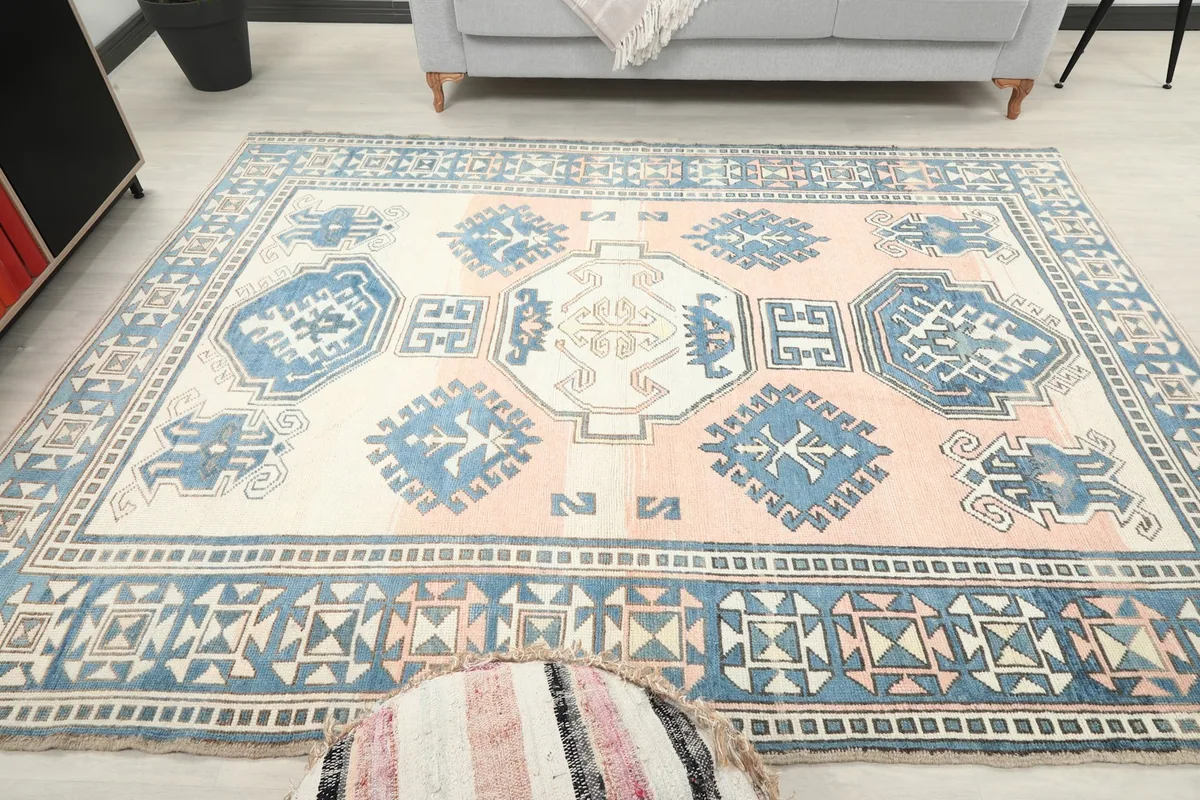 Full room shot with the rose and blue rug as a focal point, showing surrounding decor