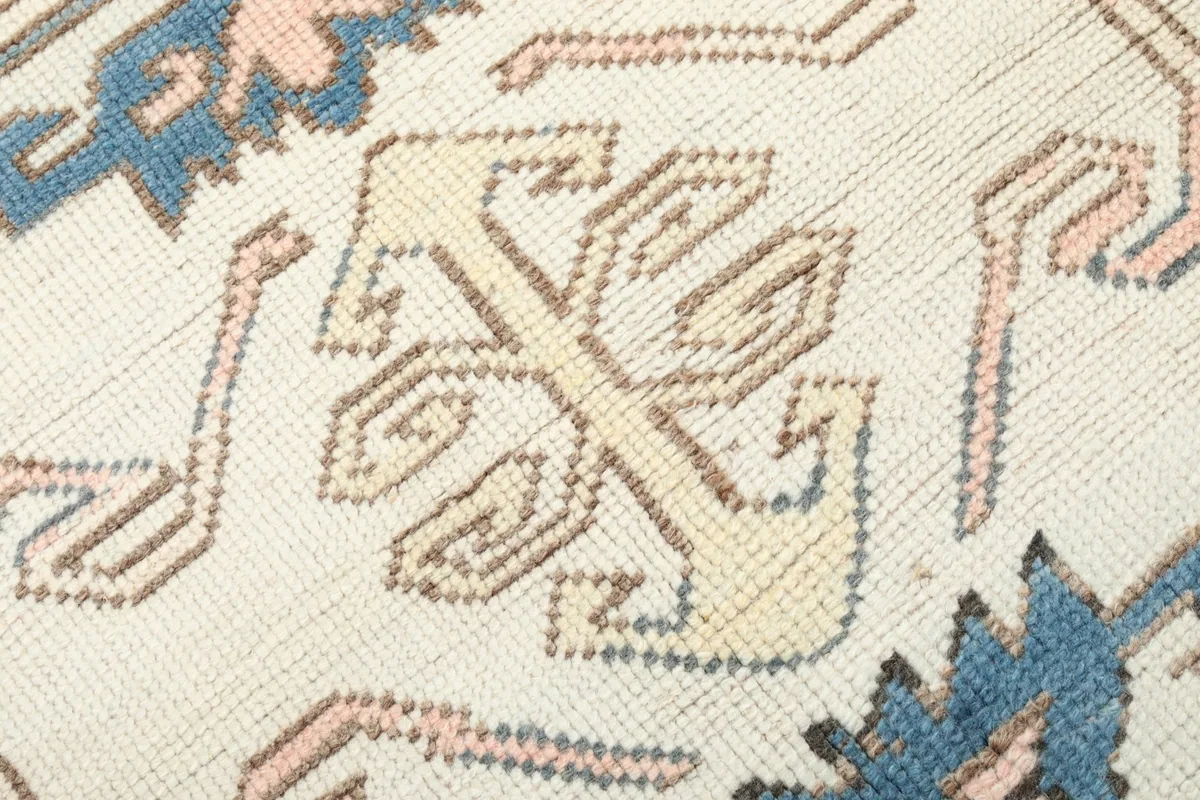 Extreme close-up showing the low wool pile and intricate knotting of the rug