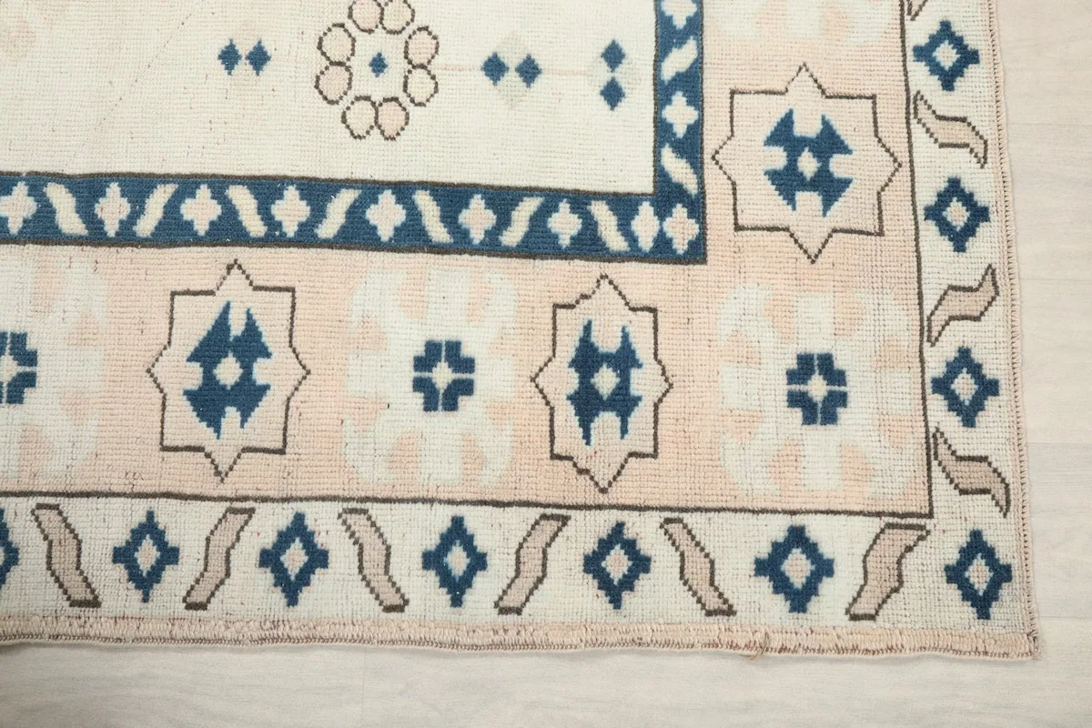 Detail of the corner showing the beige outer border and navy inner border patterns