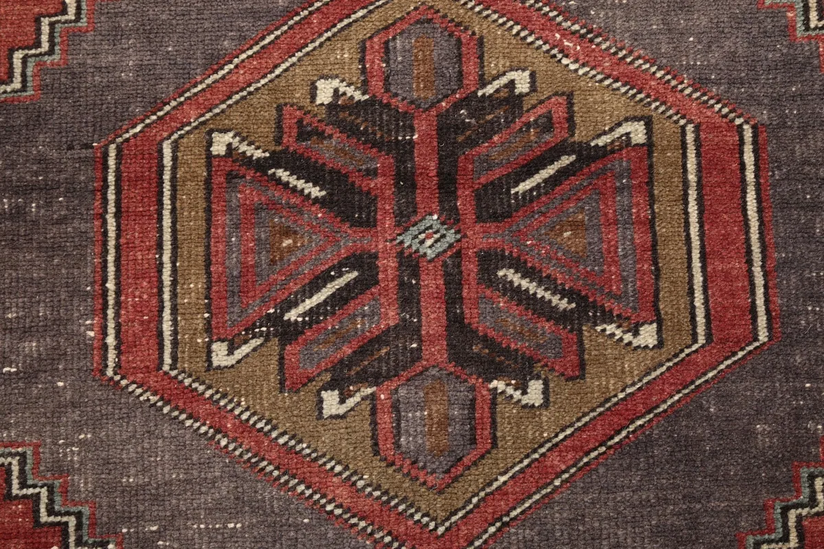 Intricate detail of the geometric design within the rug's central medallion