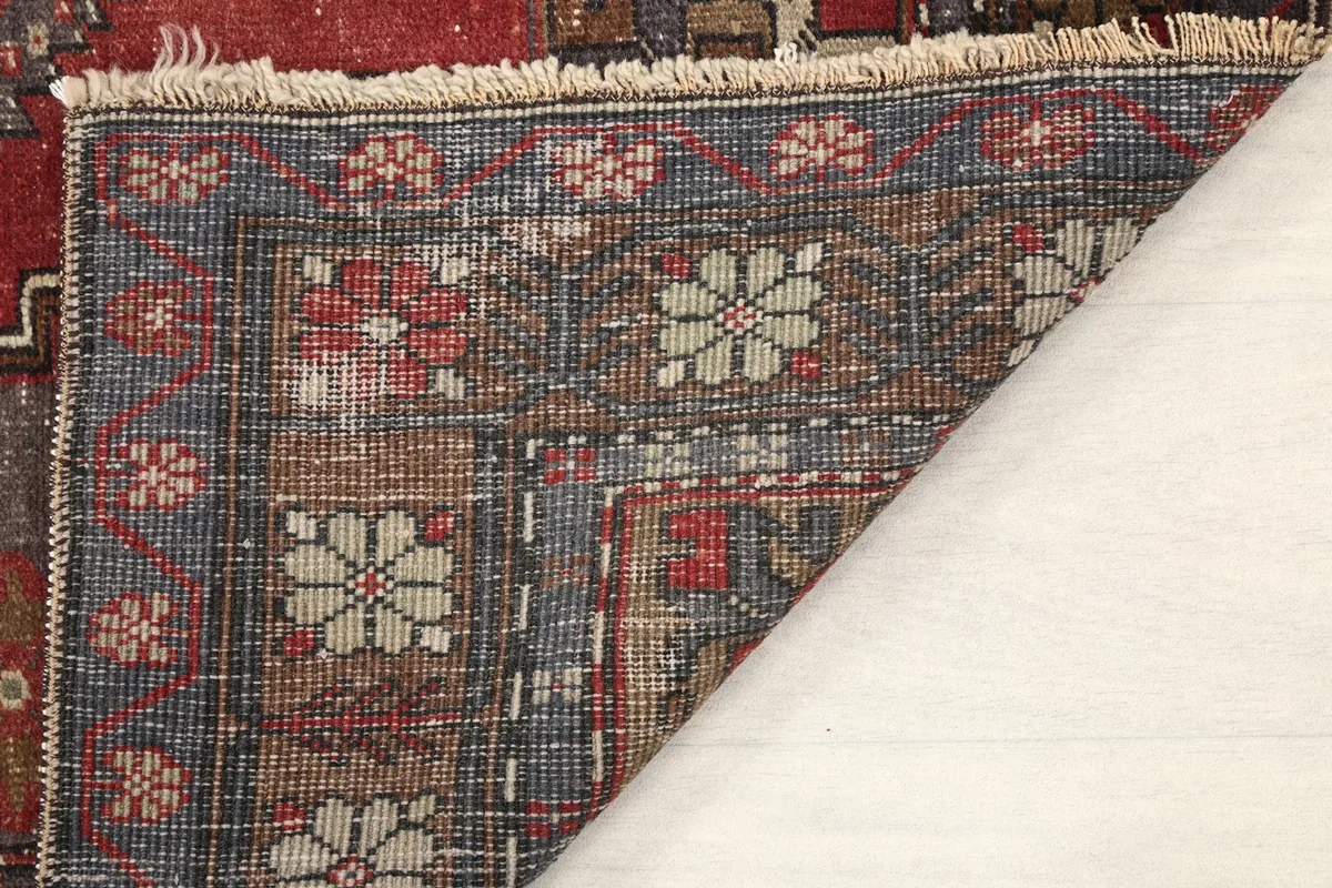 Close-up of the rug's cotton foundation and hand-knotted construction from the back
