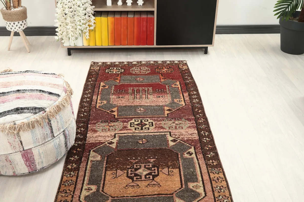 View of the runner rug from the end, showing its placement in a room with a sofa and shelving.
