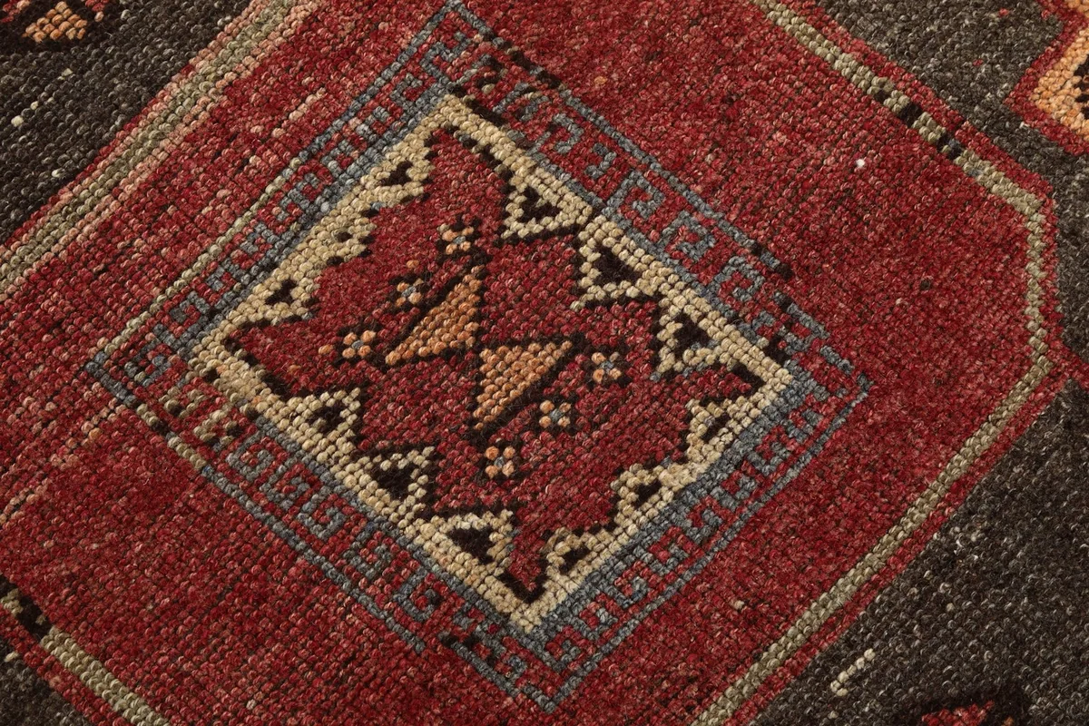 Very close-up of the central motif, revealing the hand-knotted wool pile and subtle color variations.