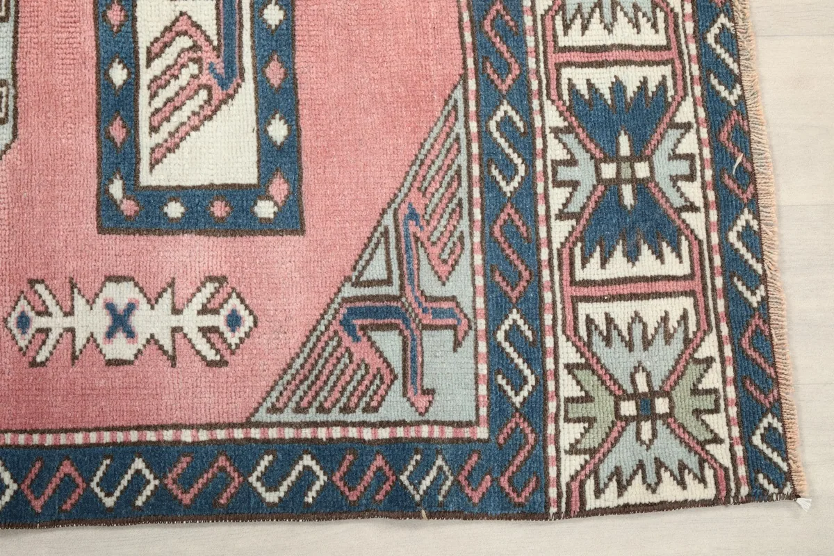 Detailed view of the navy border and corner geometric patterns on the rug
