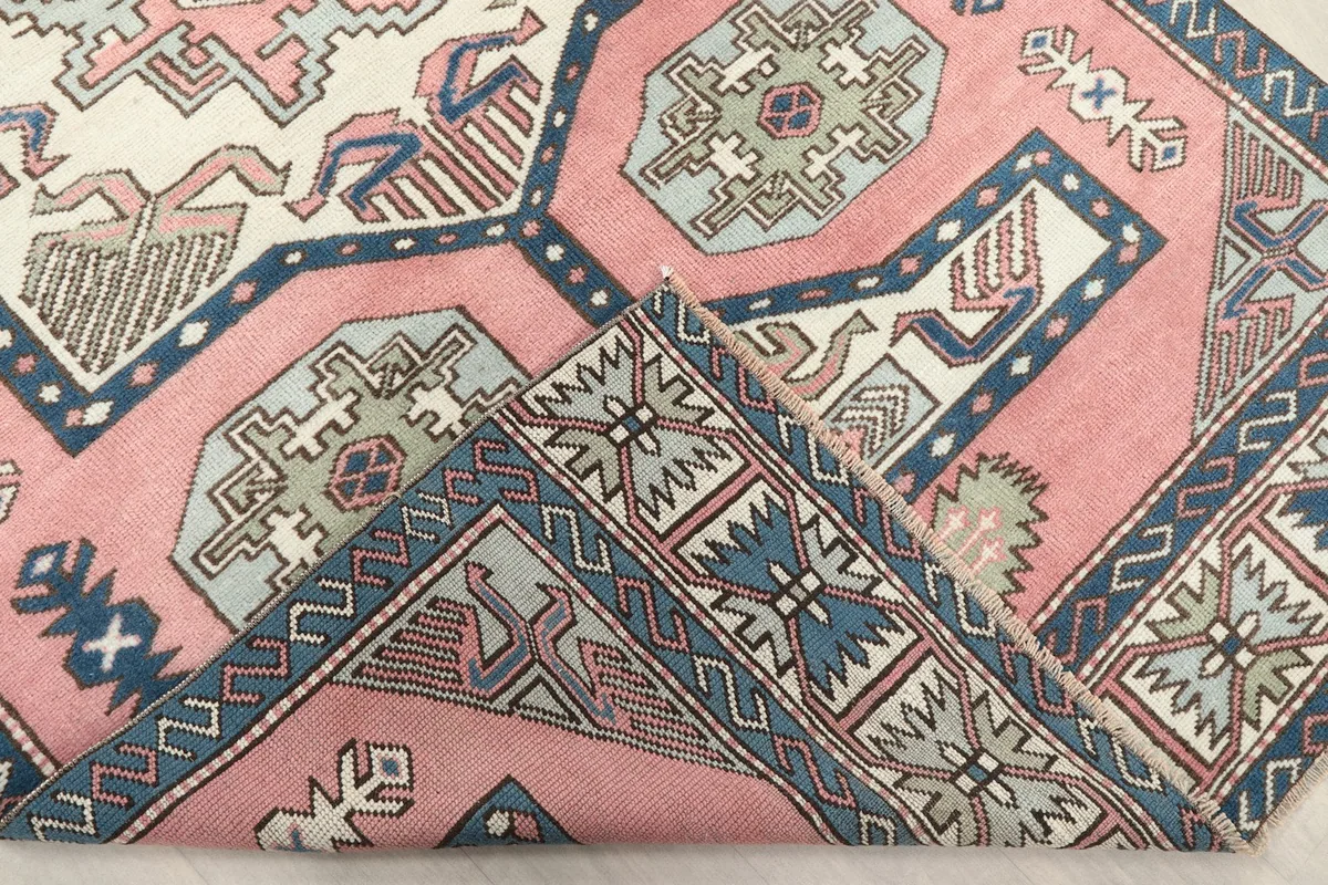 Folded corner of the rug revealing the hand-knotted construction and wool pile