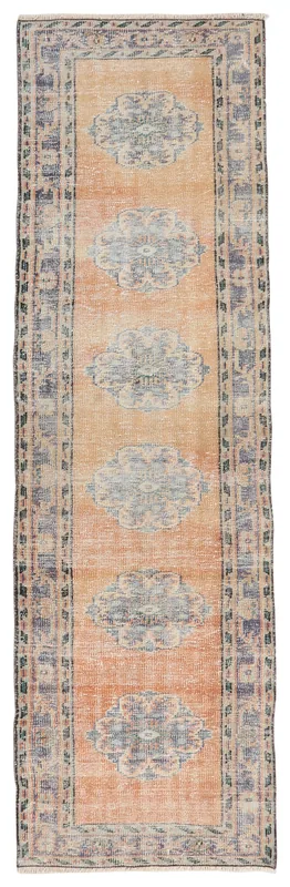 Full overhead view of the rust runner rug with blue medallions on a white background.