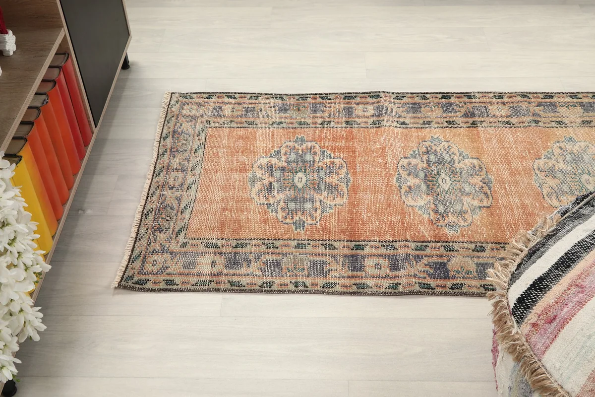 Angled view of the runner rug stretching across the floor, next to a colorful bookshelf.