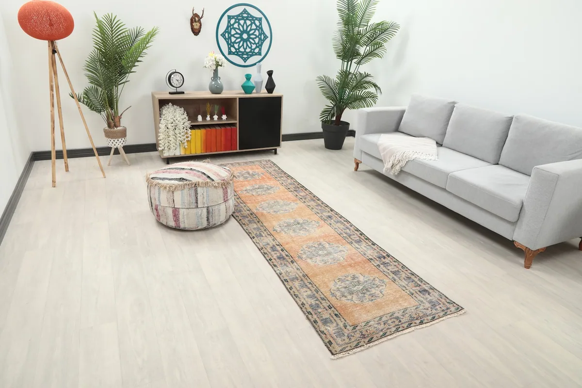 Angled view of the runner rug in a room, highlighting its placement next to a sofa and ottoman.
