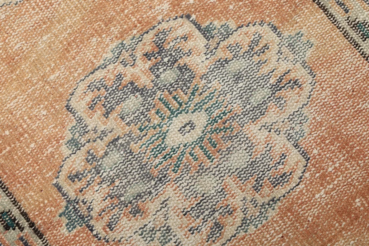 Macro detail shot of a single blue medallion, revealing the intricate hand-knotted wool pile.