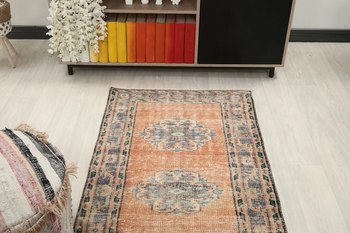 Overhead view of the rug in a room setting, focusing on the central design and border patterns.