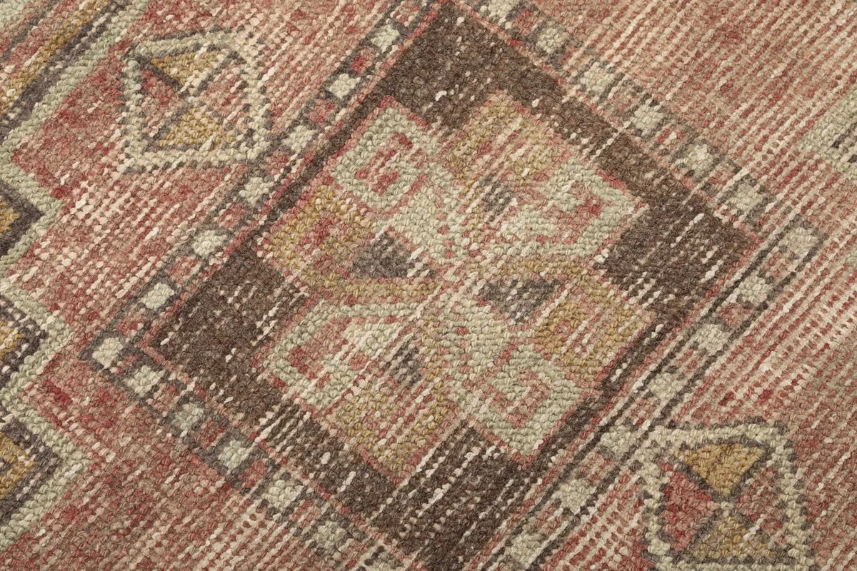 Extreme close-up showing the low wool pile and the hand-knotted texture of the rug.