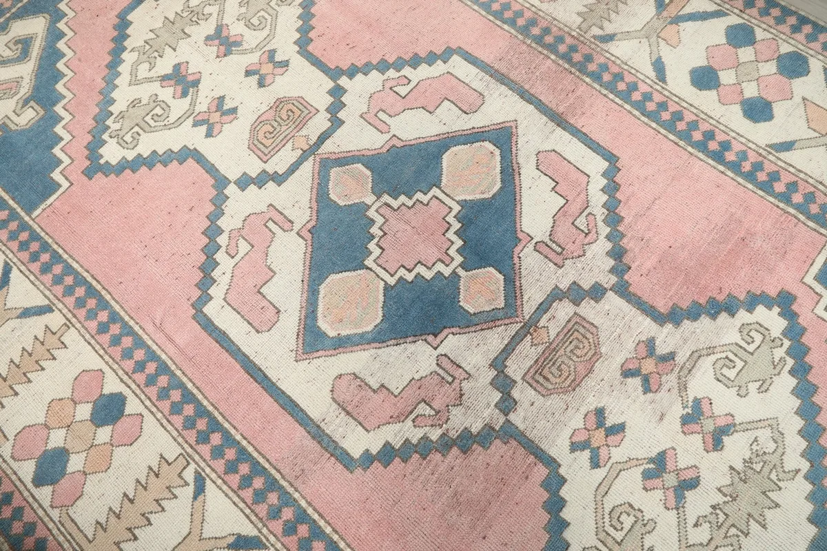 Close-up of the central medallion with pink and blue geometric shapes