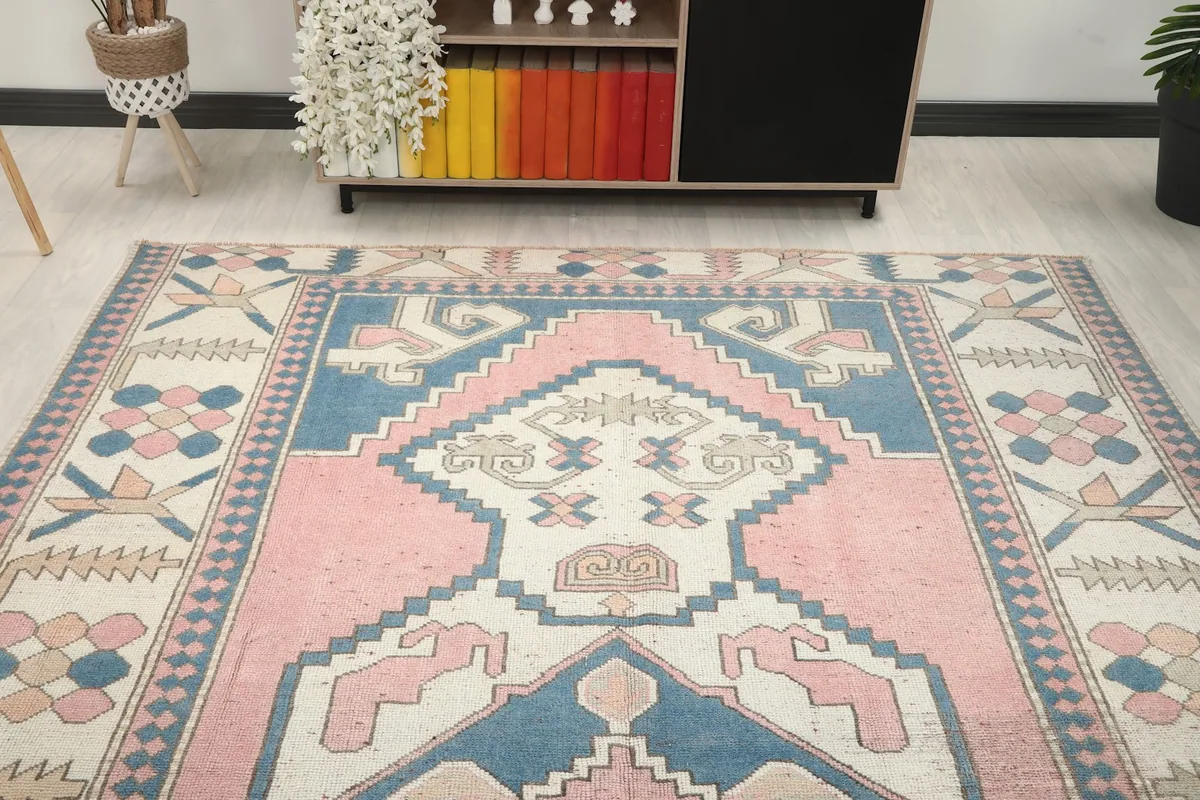 Overhead view showcasing the top half of the pink and blue vintage rug in a room