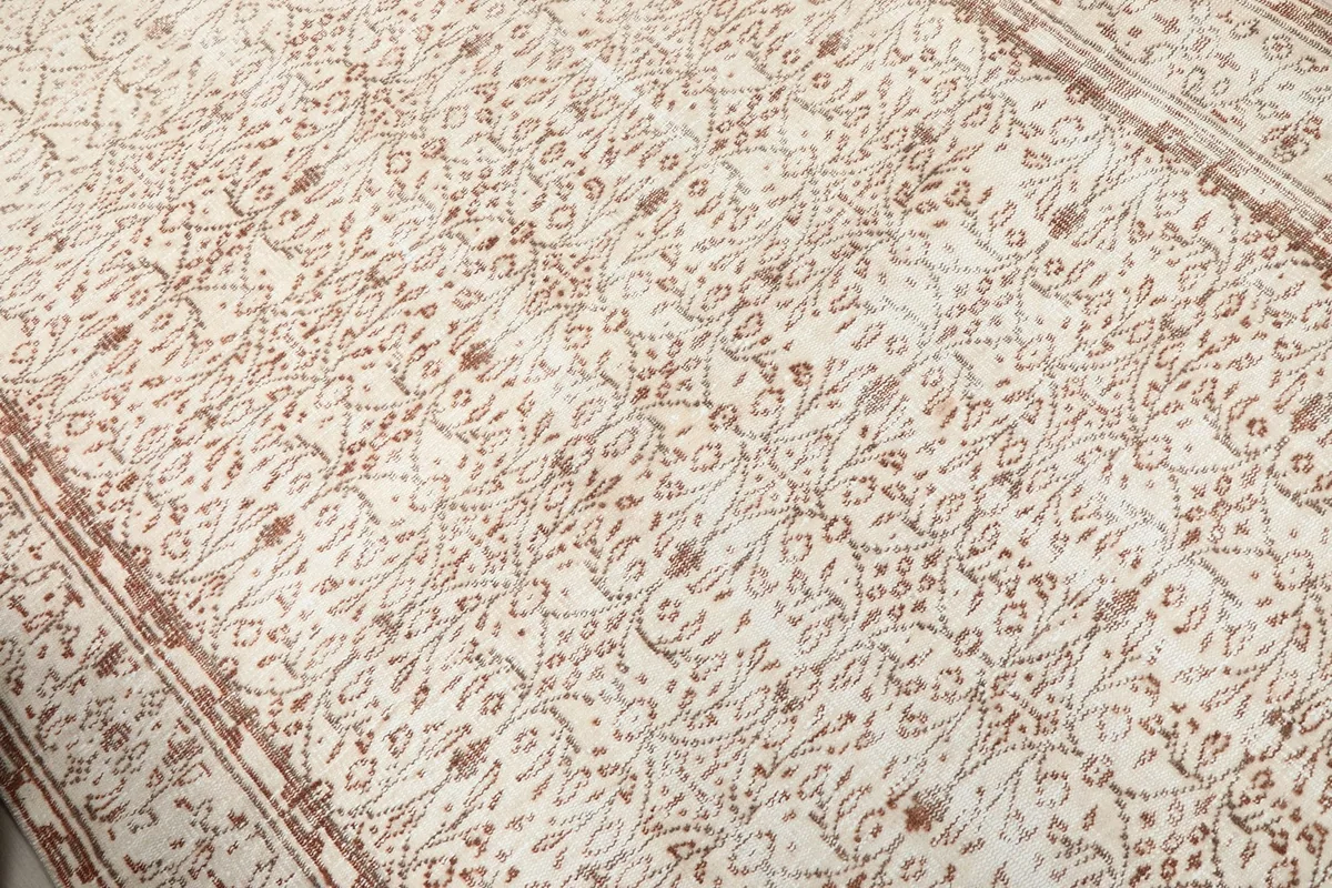 Close-up of the all-over rust floral and geometric pattern on ivory field