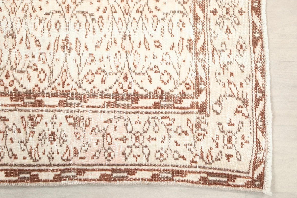 Detailed view of the rust colored border and corner of the vintage rug