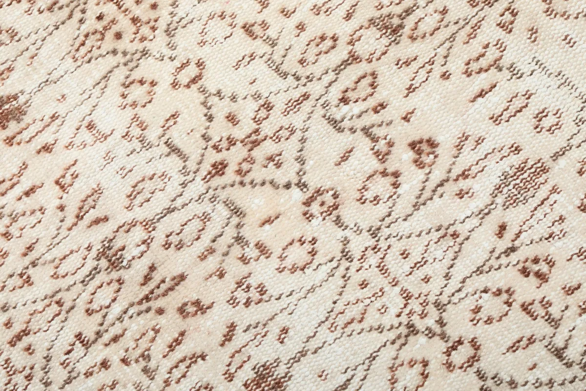Texture and low pile of the hand-knotted wool rug showing vintage wear