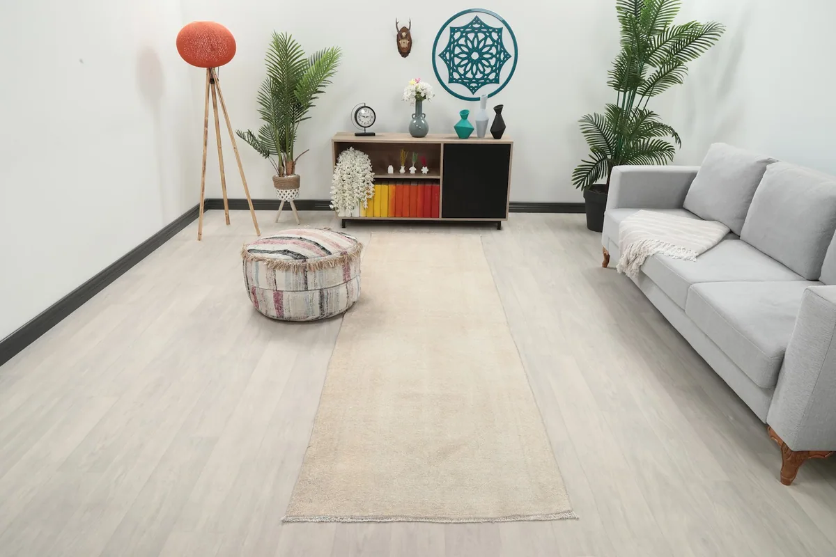 Vintage ivory runner rug placed in a modern living room setting, showing its scale relative to furniture.