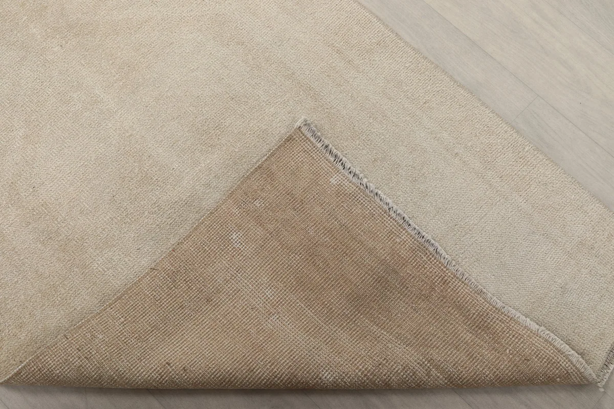 Underside view of the rug, revealing the cotton foundation and the reverse of the hand-knotted wool pile.