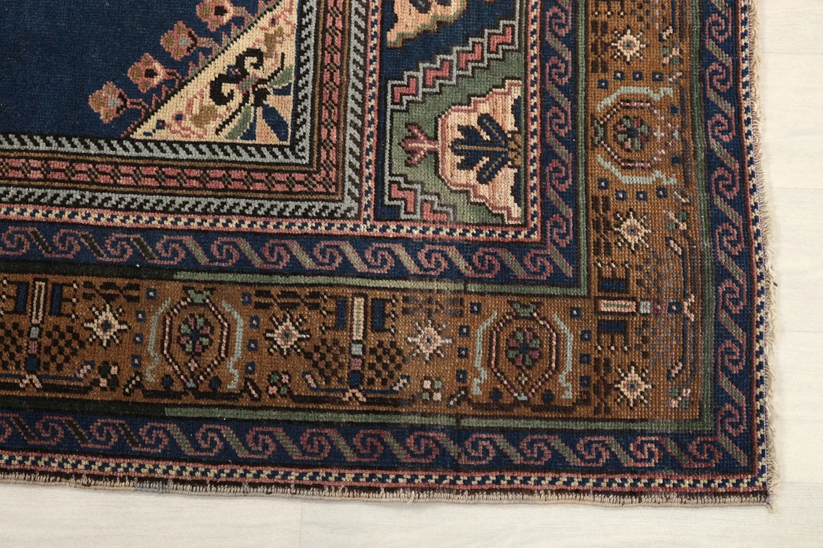 Detailed view of the corner border design, showing geometric patterns in brown, navy, and green