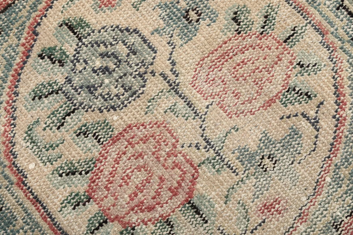 Extreme close-up of the hand-knotted wool pile and floral patterns within the medallion