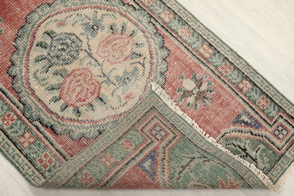 Corner of the rug folded to reveal the cotton foundation and reverse side of the knots