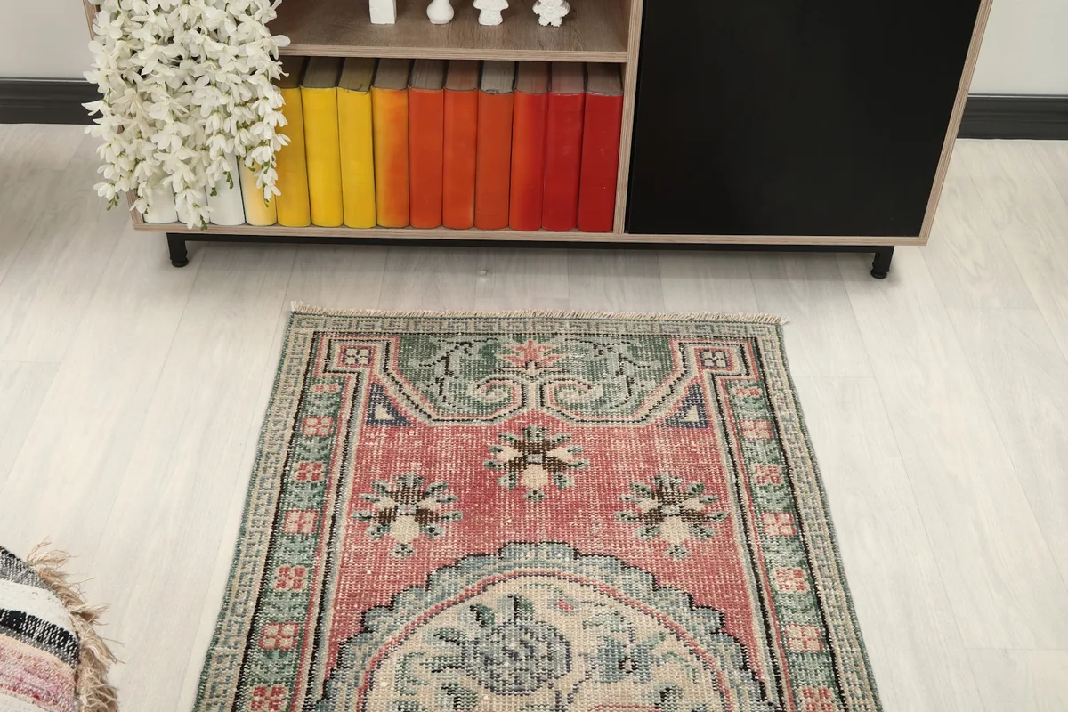 Overhead view of the rug's upper section, showing the green border and rose field
