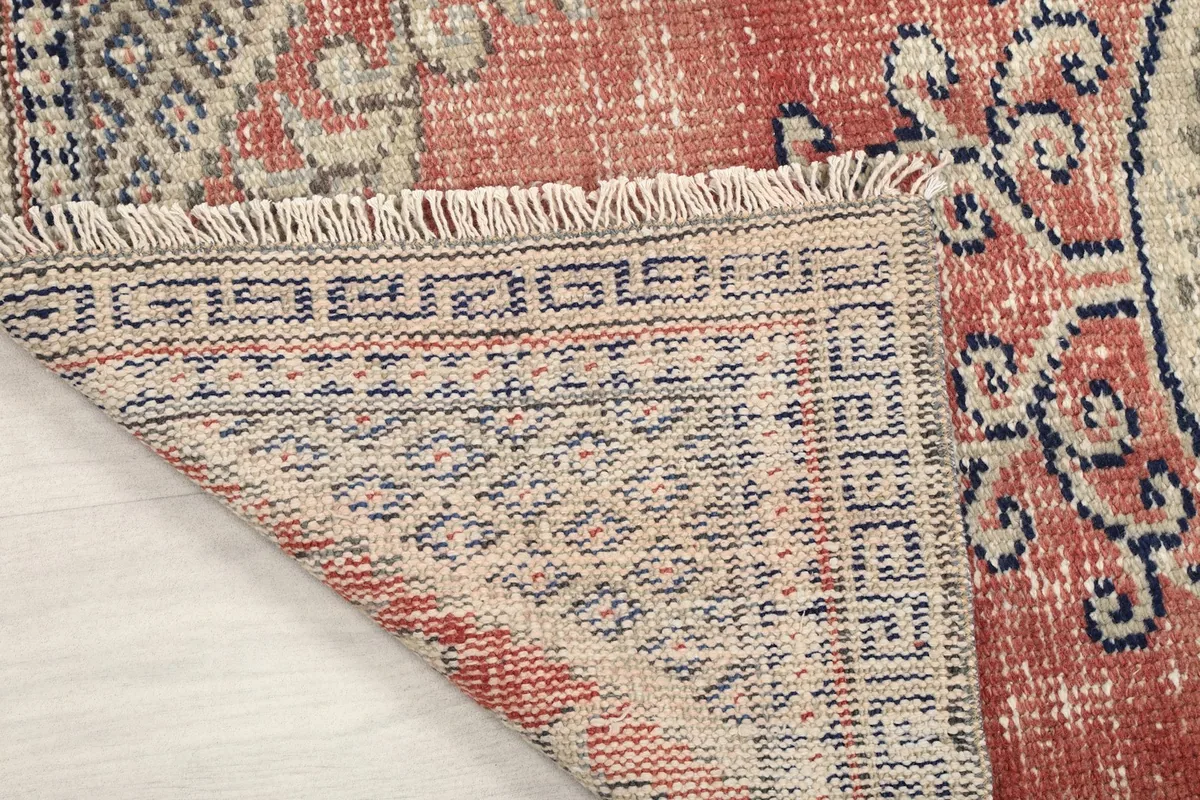 Close-up of the rug's reverse side, showing the intricate knotting and fringe details.