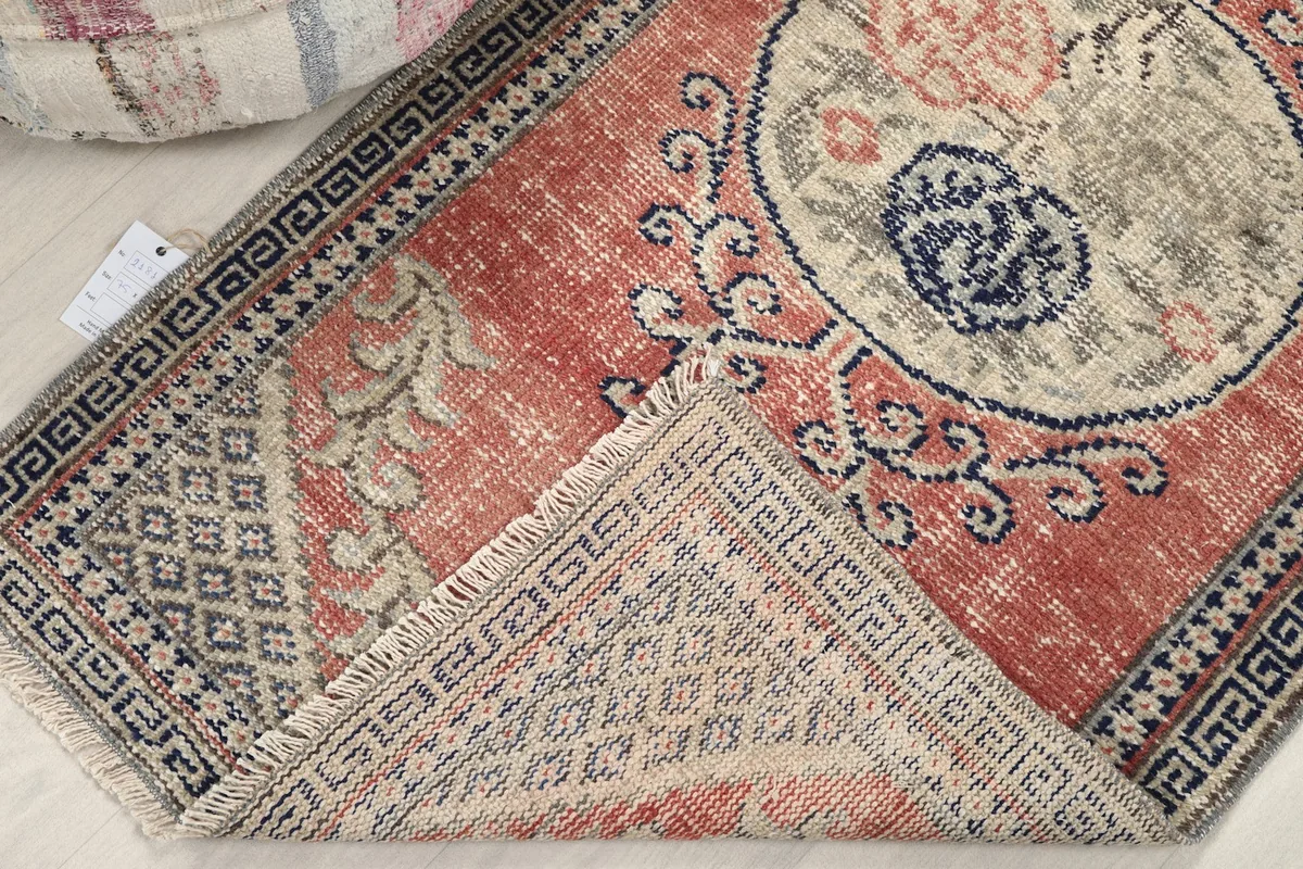 Rug corner folded back to reveal the cotton foundation and hand-knotted construction.