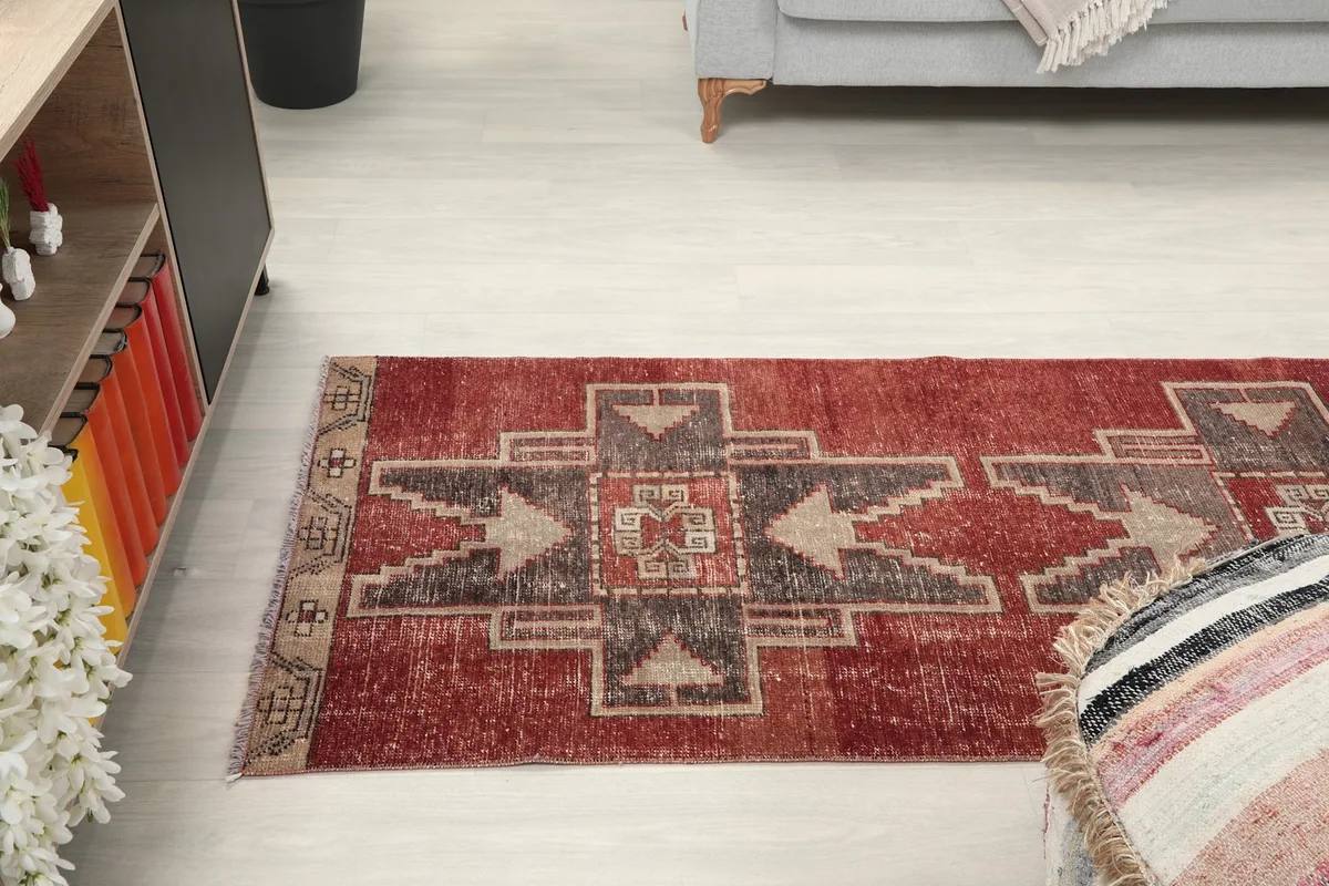 Room view showing the runner rug extending towards a sofa, with a decorative pouf in foreground