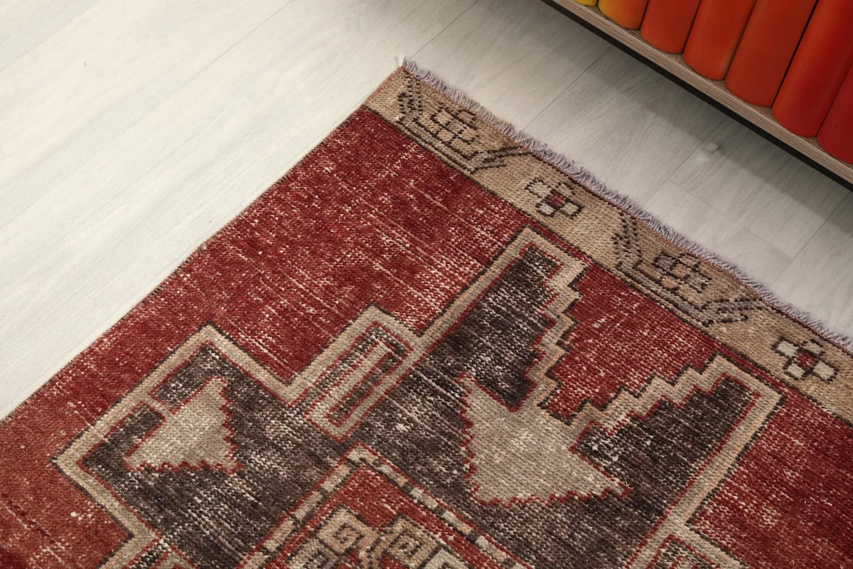 Close-up of the rug's corner and border design, highlighting the tan and charcoal accents