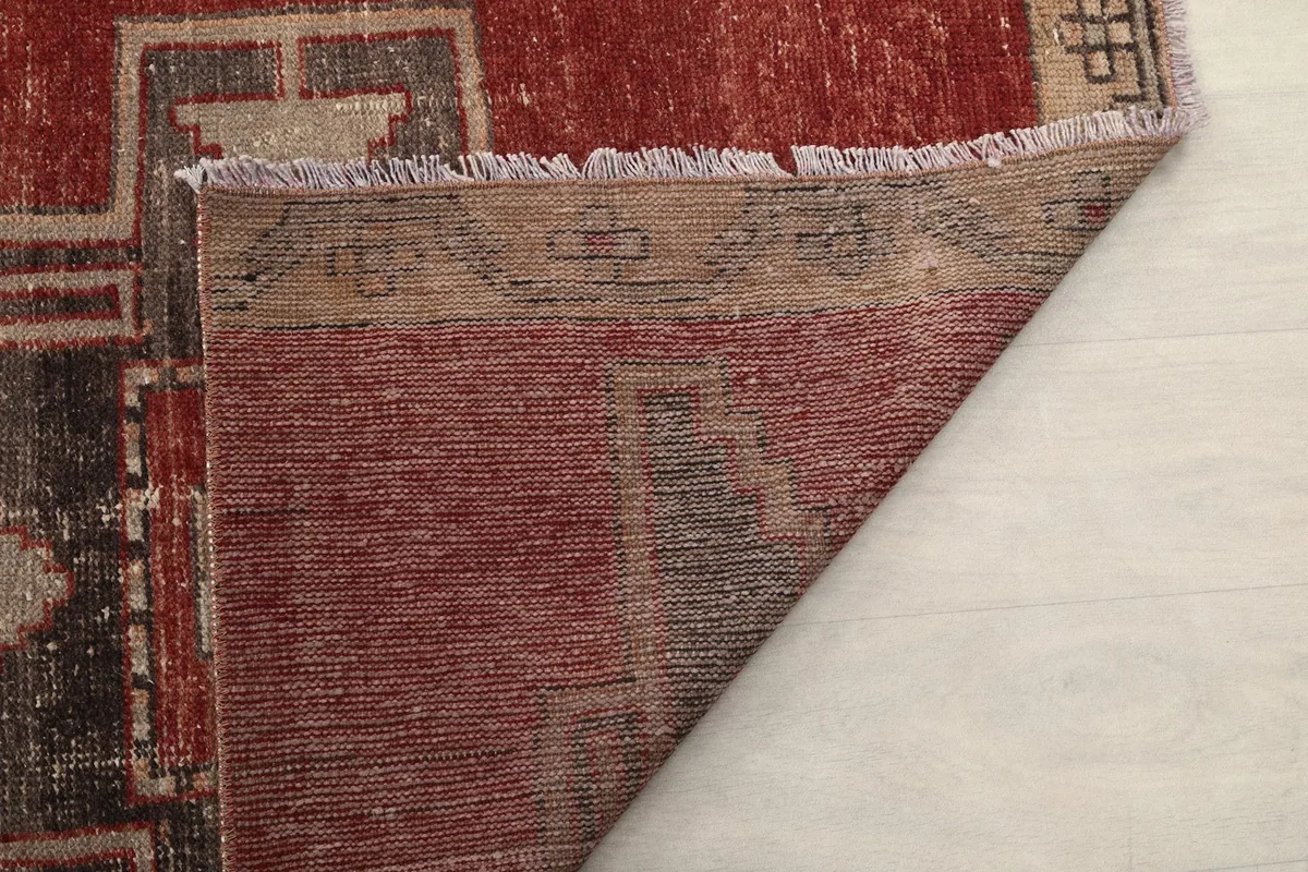 Close-up of the rug's underside, showing the hand-knotted construction and fringe
