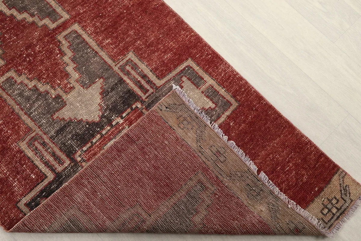 Corner of the rug folded back to reveal the back of the hand-knotted cotton foundation