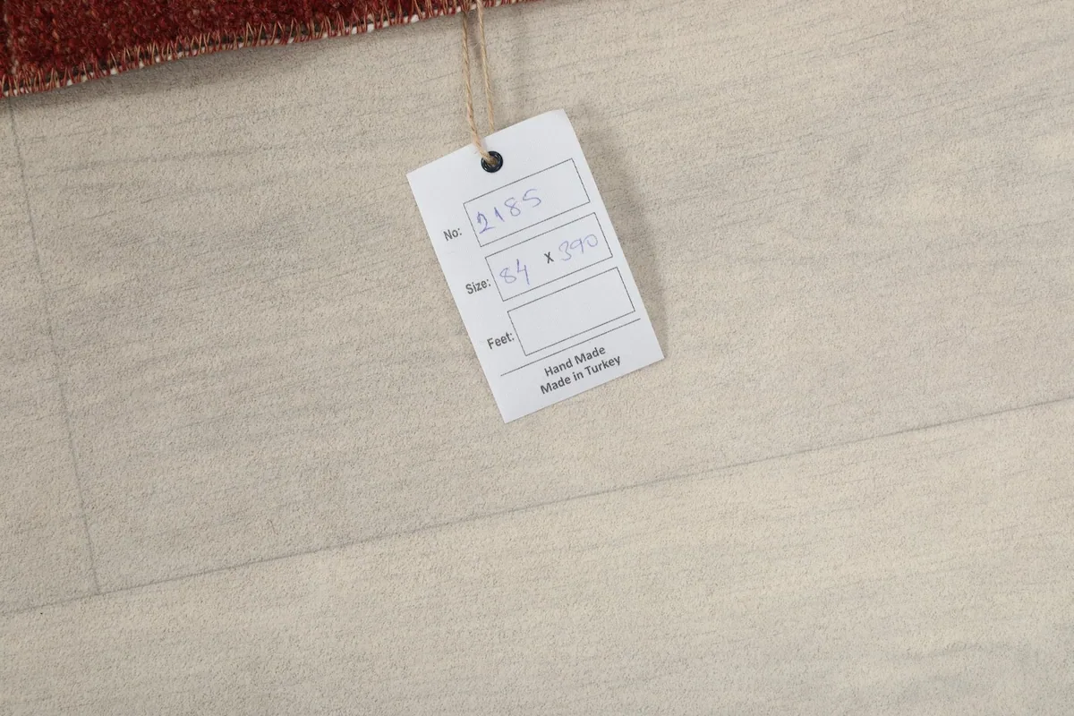 Product tag attached to the rug, indicating it is hand-made in Turkey