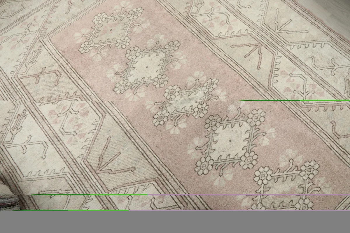 Angled close-up showing the central pink field and floral motifs