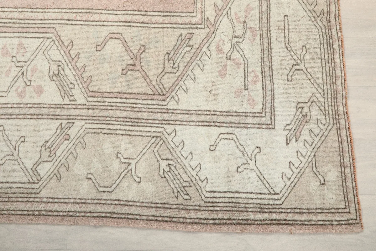 Detail of the geometric patterns in the beige border of the rug